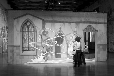 Visitors ponder a small part of artist Jim Shaw's sprawling exhibit, "Entertaining Doubts," which opened in late March at Mass MoCA. John Seven photo