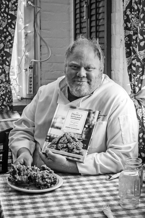 Jasper Alexander, the chef at Hattie’s Restaurant in Saratoga Springs, shows off his new cookbook and a plate of the Southern fried chicken the restaurant has been serving since it opened in 1938. Joan K. Lentini photo
