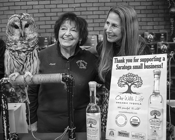 Lisa Elovich, right, the owner and founder of the One With Life brand of organic tequila, is joined by Joyce Perry, director of Whispering Willow Wild Care, and the barred owl Ophelia at an event held in November at All Star Wine & Spirits in Latham, N.Y. Joan K. Lentini photo