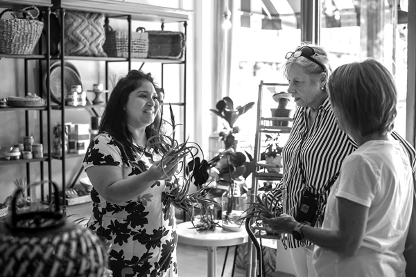 Dayanis Bowie, owner of the DB Trends boutique in Ballston Spa, shows customers Jude Hughes of Amherst, Mass., and Sandy Staniec of Syracuse an “air plant” from Guatemala that grows without soil. Joan K. Lentini photo